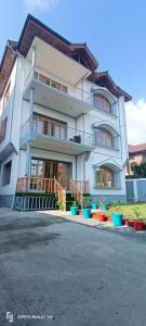 a large white building with colorful pots in front of it at Moonshine Home stay in Srinagar