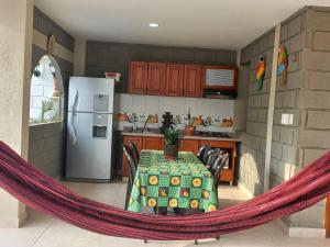 a kitchen with a hammock around a table and a refrigerator at Rancho Ayala II in Santa Marta