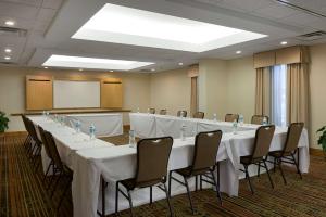 una sala de conferencias con una mesa larga con mesas y sillas blancas en Hampton Inn & Suites Charlotte/Pineville en Charlotte