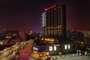 un edificio alto con una luz roja en la parte superior por la noche en Hilton Garden Inn Shenzhen Bao'an en Bao'an