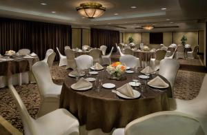 uma sala de banquetes com mesas, cadeiras brancas e mesa em Embassy Suites by Hilton Washington DC Chevy Chase Pavilion em Washington