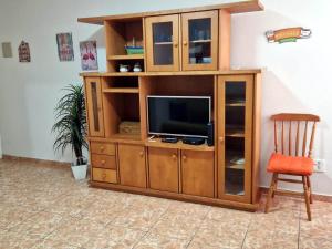 un centro de entretenimiento de madera con TV y silla en Very close to Copacabana beach!, en Río de Janeiro