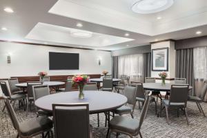 a conference room with tables and chairs and a flat screen tv at Hampton Inn Hartford Airport in Windsor Locks