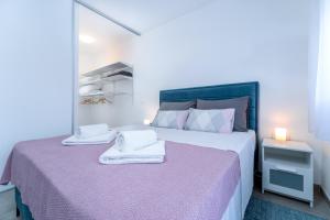 1 dormitorio con 1 cama grande y toallas. en Sunrise & Sunset Apartmani - Self Check In, en Osijek