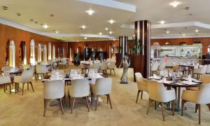 un comedor con mesas y sillas blancas en Transcorp Hilton Abuja, en Abuja