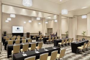 a conference room with tables and chairs and a screen at DoubleTree by Hilton Hotel Albuquerque in Albuquerque