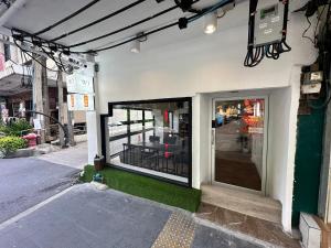 a store front with a glass door on a street at The White Den Sukhumvit 44 in Bangkok