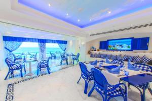 Hilton Alexandria Corniche Hotel في الإسكندرية: غرفة طعام مع كراسي وطاولات زرقاء