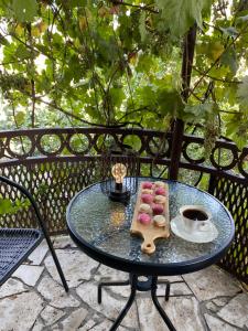 einen Tisch mit einem Tablett mit Gebäck und einer Tasse Kaffee in der Unterkunft EleGaya Guest house in Idschewan