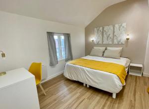 een slaapkamer met een bed met een gele deken bij Le Cocon - logement 4 personnes - Neuf - Wifi in Le Bourget