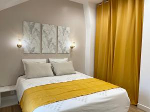 a bedroom with a bed with a yellow curtain at Le Cocon - logement 4 personnes - Neuf - Wifi in Le Bourget