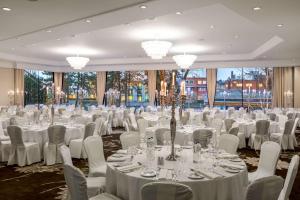 une salle de banquet avec des tables blanches, des chaises et des lustres dans l'établissement Hilton Amsterdam, à Amsterdam