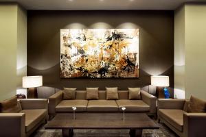 a living room with a couch and a painting at Ankara HiltonSA in Ankara