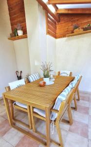 uma mesa de madeira com cadeiras e um tecto de madeira em Dora Holiday House & Apartments em Keszthely