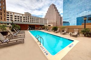 オースティンにあるHampton Inn & Suites Austin-Downtown/Convention Centerの大きなスイミングプール(椅子付)と建物