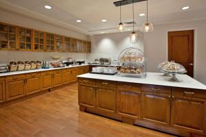a large kitchen with wooden cabinets and white counter tops at Hampton Inn & Suites Austin-Downtown/Convention Center in Austin