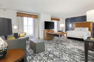 オースティンにあるHampton Inn & Suites Austin-Downtown/Convention Centerのベッドとリビングルームがあるホテルの部屋