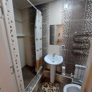 a small bathroom with a sink and a shower at Vintage гостиница in Shchūchīnsk