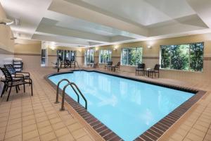 una piscina en una habitación de hotel con sillas y mesas en Hilton Garden Inn Blacksburg University, en Blacksburg