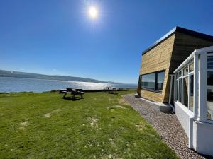 a building with a picnic table next to the water at Spacious Sea View Home 5 miles from Inverness in North Kessock
