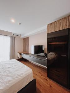 een hotelkamer met een bed en een flatscreen-tv bij Beststay @Mataramcity yudhistira tower in Kejayan