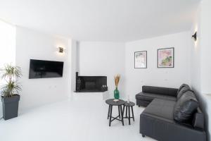 uma sala de estar com um sofá preto e uma mesa em SyntheSeas Residence em Rethymno Town