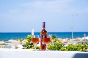 a bottle of wine sitting on a table with two glasses at SyntheSeas Residence in Rethymno Town