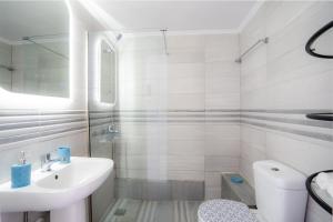 a white bathroom with a sink and a toilet at SyntheSeas Residence in Rethymno Town +51 photos