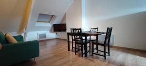 a dining room with a table and chairs and a couch at N°6 Annœullin - Appt 2 Chambres in Annoeullin