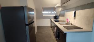 a small kitchen with a sink and a refrigerator at TOK TOK A6 - Appartement 2Ch Toutes commodités in Annoeullin