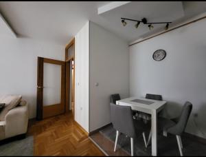 una sala da pranzo con tavolo e sedie bianchi di Apartman KostaS a Lukavica