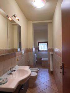 uma casa de banho com um lavatório, um WC e um espelho. em B&B Terra & Sole em Novafeltria