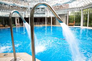 a swimming pool with two water jets in it at Hilton Birmingham Metropole Hotel in Bickenhill