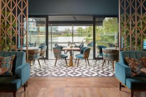 a restaurant with tables and chairs and a view of the water at Hilton Birmingham Metropole Hotel in Bickenhill