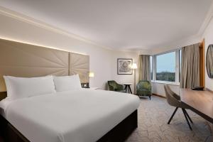 een hotelkamer met een groot bed en een bureau bij Hilton Birmingham Metropole Hotel in Bickenhill