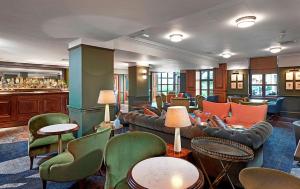 格洛斯特Hilton Puckrup Hall Hotel & Golf Club, Tewkesbury的配有沙发、椅子和酒吧的大堂