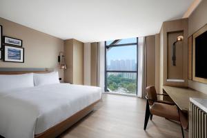 una camera da letto con un letto, una scrivania e una finestra di Four Points by Sheraton Shenzhen Bao'an a Shenzhen