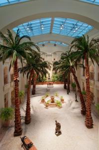 孟買的住宿－希爾頓孟買國際機場酒店，一间大客房,位于一座建筑中,种植了棕榈树