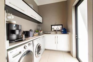 a laundry room with a washer and dryer at Laru home in Germiston