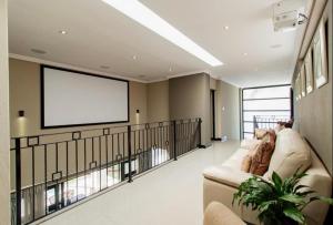 a large living room with a couch and a screen at Laru home in Germiston