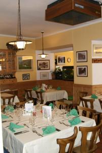 a dining room with white tables and chairs at Albergo Piz Cam in Vicosoprano