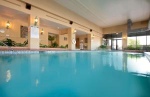 a large swimming pool in a hotel with blue water at Embassy Suites by Hilton Columbia Greystone in Columbia