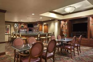 a restaurant with tables and chairs and a flat screen tv at Embassy Suites by Hilton Columbia Greystone in Columbia