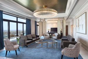 a living room with couches and chairs and a chandelier at Conrad Cairo Hotel & Casino in Cairo