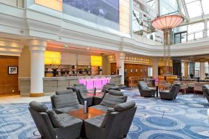 a lobby with chairs and a table and a bar at Hilton Paris Charles De Gaulle Airport in Roissy-en-France