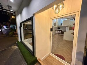 eine Tür zu einem Zimmer mit grünem Boden in der Unterkunft The White Den Sukhumvit 44 in Bangkok