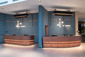 a lobby with two reception desks and chandeliers at Hilton Cologne in Cologne