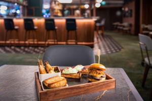 ein Tablett mit Essen auf einem Tisch mit einem Sandwich und Pommes frites in der Unterkunft Hilton Cologne in Köln