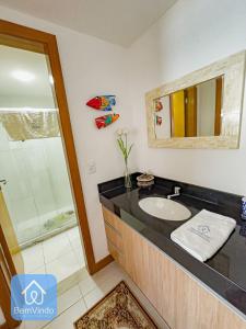 uma casa de banho com um lavatório e um chuveiro em Apartamento com Incrível Vista Mar em Armação em Salvador