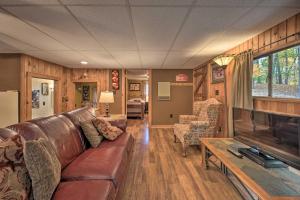 sala de estar con sofá de cuero y TV en Lucas McCain Cabin 5 Mi to Raystown Lake Launch!, en Huntingdon